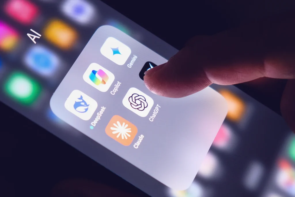 Person selecting an AI assistant app on a phone to book business travel